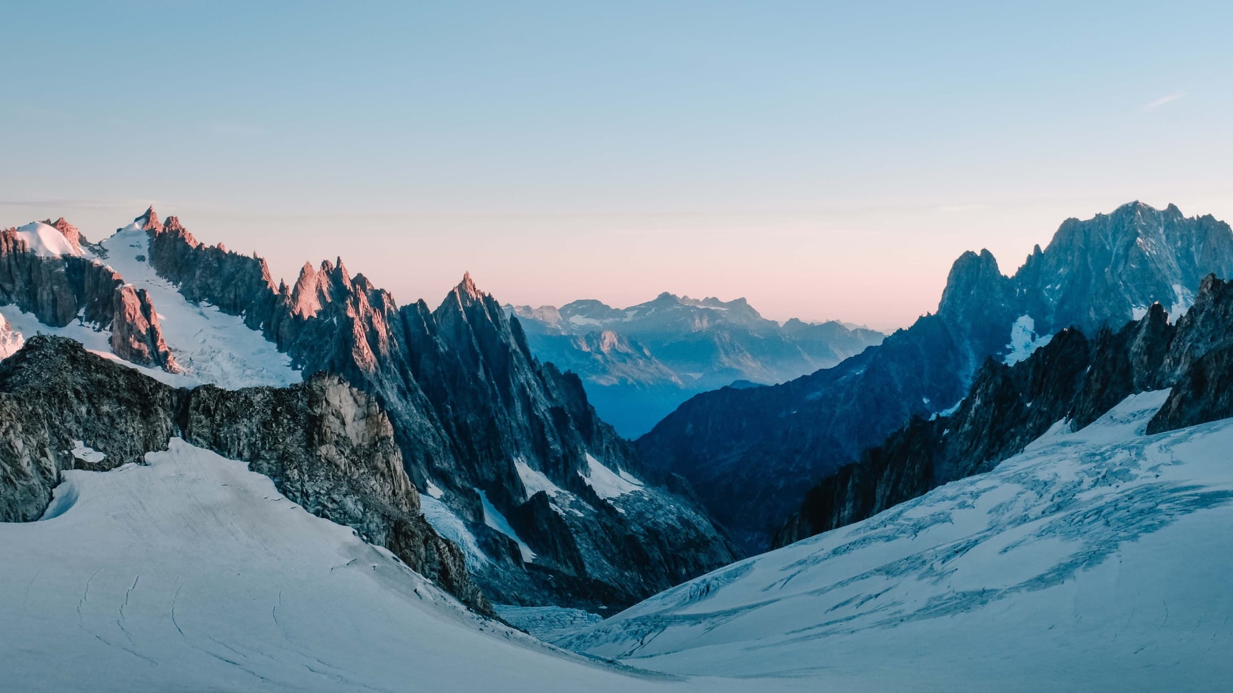 A vast line of snow-covered mountain peaks